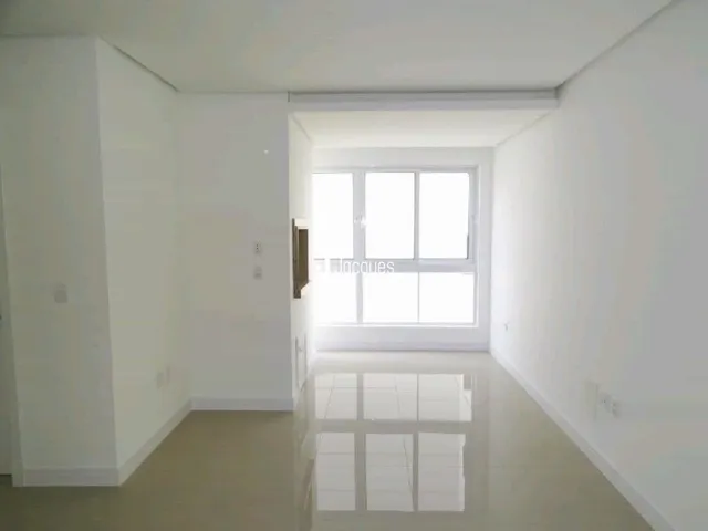 Vista interna de um ambiente com paredes brancas e uma janela.