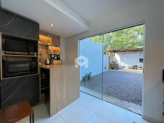 Sala de estar com porta de vidro abrindo para o quintal.