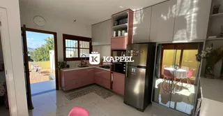 Esta é uma foto de uma cozinha moderna com armários em tons de rosa e piso de porcelanato claro.