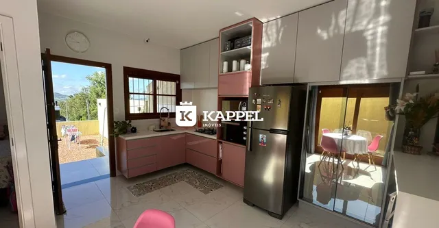 Esta é uma foto de uma cozinha moderna com armários em tons de rosa e piso de porcelanato claro.