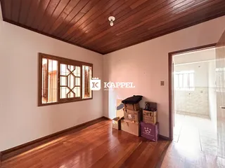 Uma sala de estar com piso de madeira e janela no ambiente.