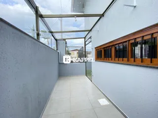 Hall de entrada com piso de cerâmica e vista externa através de grandes painéis de vidro.