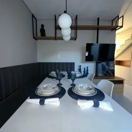 Uma mesa de jantar com louças está montada em um ambiente interno.