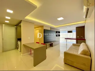 Sala de estar clara com sofá de cor bege e piso de cerâmica.
