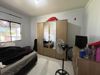 Quarto com armários de madeira e janela de grande porte.