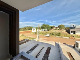 Vista da área externa com paisagem rural ao fundo.