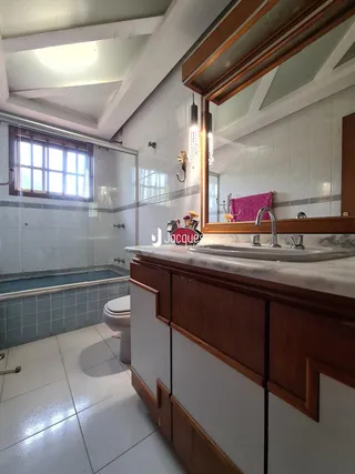 Foto de um banheiro com revestimento cerâmico e bancada de mármore.