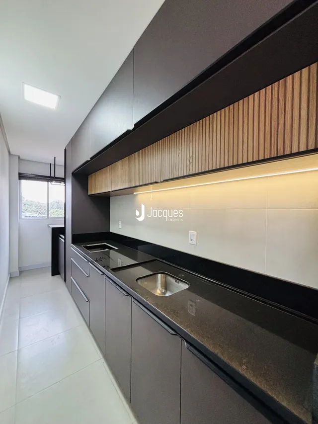 Cozinha moderna com armários escuros e detalhes em madeira.