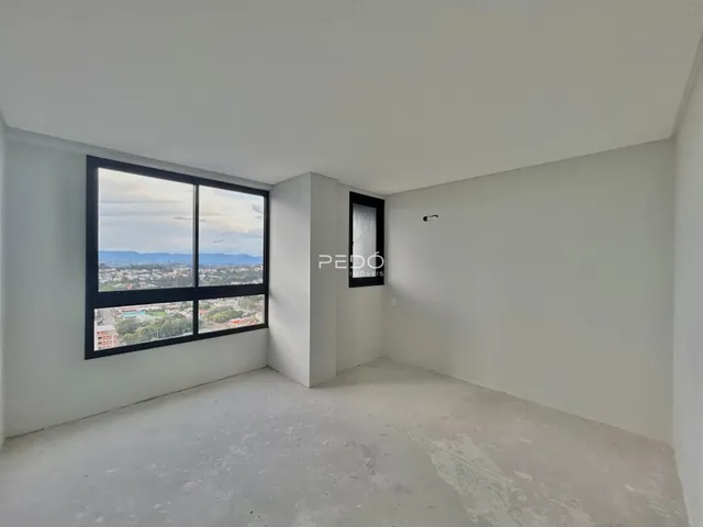 Ambiente interno com grande janela de vista para a paisagem.