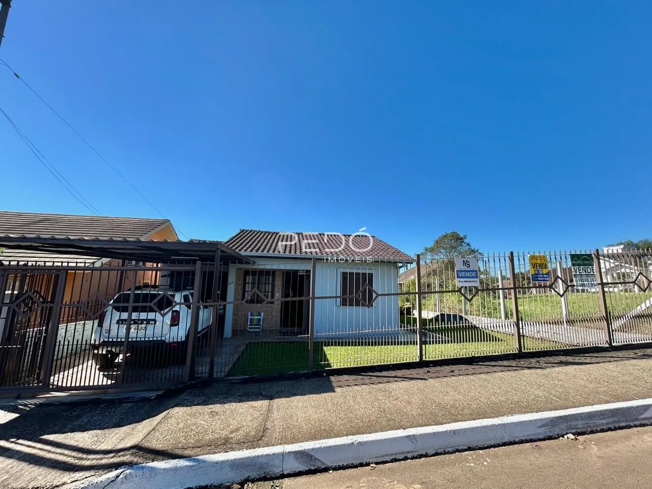 Fachada de uma casa em Lajeado, Brasil, com cerca e portão.