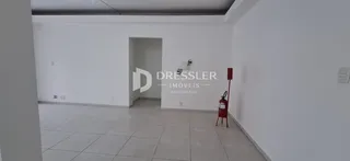 Hall de entrada com piso de cerâmica e paredes brancas.