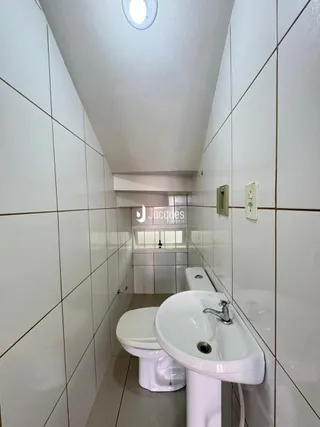 Foto de um banheiro com azulejos brancos.