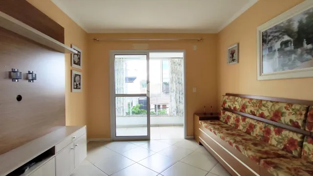Ambiente interno de um apartamento com porta de vidro abrindo para a varanda.