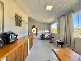 Sala de estar com bancada de madeira e área de refeições em um apartamento.