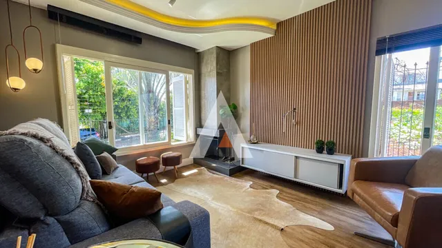Sala de estar com grandes janelas e decoração moderna.