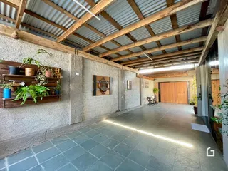 Espaço interno com teto de telha e vigas de madeira expostas.