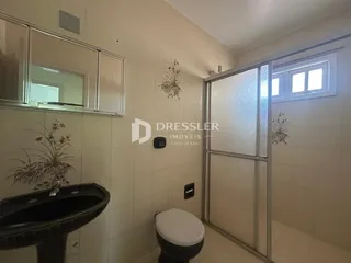 Foto de um banheiro interno com revestimento cerâmico e box de vidro.
