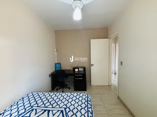 Vista interna de um corredor com piso de cerâmica e parede branca.