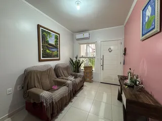 Sala de estar com dois sofás e decoração de parede em uma residência.