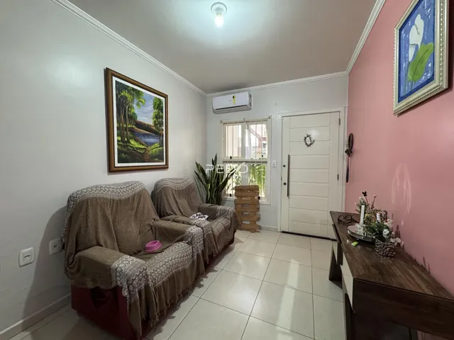 Sala de estar com dois sofás e decoração de parede em uma residência.