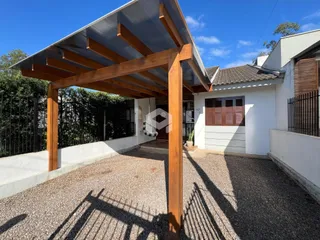 Fachada de uma casa em Lajeado com uma estrutura de madeira e muro.