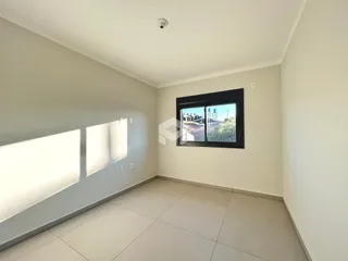 Ambiente interno de uma sala com piso de cerâmica e janela.