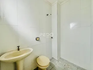 Banheiro com azulejos brancos e louças sanitárias