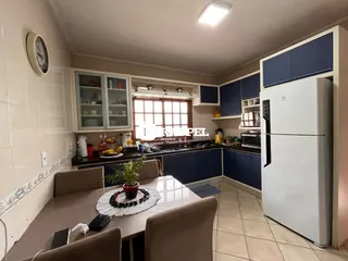 Foto de uma cozinha com armários azuis e mesa de jantar.
