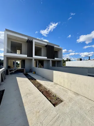 Fachada moderna de uma residência de dois andares em Lajeado, Brasil, com calçada frontal.