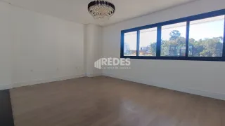 Sala de estar com grandes janelas e piso de madeira clara.