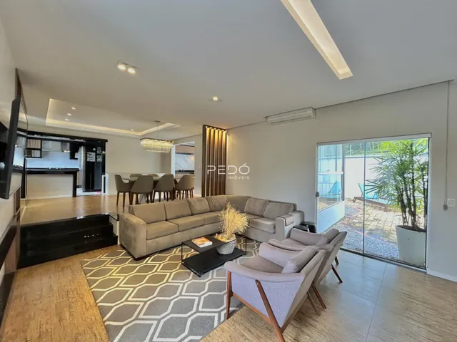 Sala de estar ampla com sofá e área de jantar em um imóvel no Brasil.