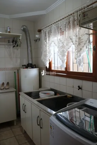 Foto de uma cozinha interna com armários brancos e revestimento de parede.