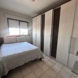 Quarto com cama e armários em um apartamento.
