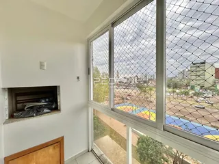 Vista da sala com grandes janelas que dão para uma área externa.