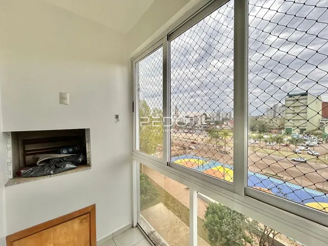 Vista da sala com grandes janelas que dão para uma área externa.