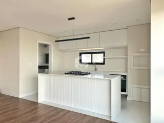Foto de uma cozinha moderna com armários brancos e piso de madeira.