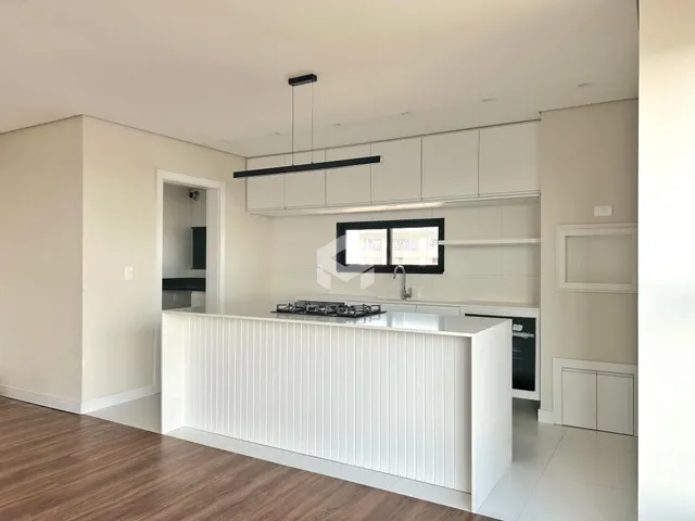 Foto de uma cozinha moderna com armários brancos e piso de madeira.