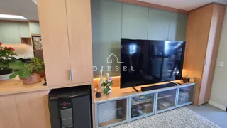 Sala de estar com painéis de madeira e rack de televisão moderno.