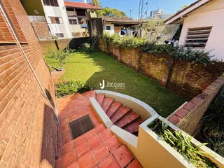 Vista do quintal com muro de tijolos e jardim em Lajeado.