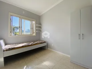 Quarto com janela e armário branco em um imóvel no Brasil.