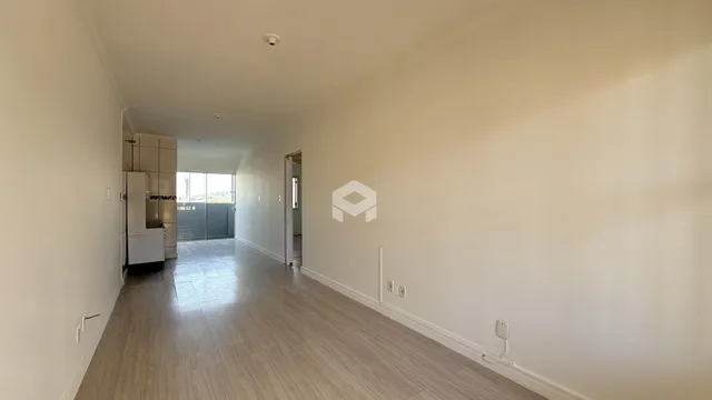 Corredor interno de uma residência com piso de cerâmica clara.