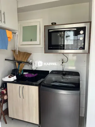 Foto de uma cozinha moderna com armários claros e bancada escura.
