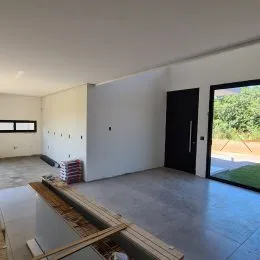 Ambiente interno com piso de concreto e parede branca.