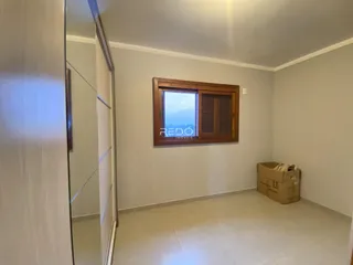Interior de uma sala com janela de madeira.
