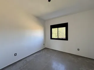 Foto de um cômodo interno com paredes brancas e piso de concreto polido.