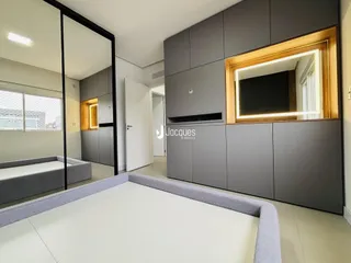 Imagem de uma sala de estar moderna com armários embutidos e espelho.