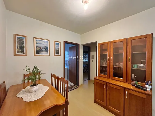 Interior de uma sala com paredes brancas e móveis de madeira.