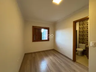 Uma sala com piso de madeira e parede clara.