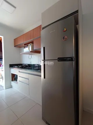 Foto de uma cozinha moderna com armários de madeira e piso claro.
