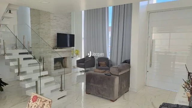 Sala de estar com escadaria e piso de mármore.